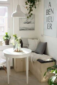 a living room with a couch, table and potted plants