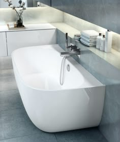 a white bath tub sitting on top of a tiled floor next to a sink and mirror