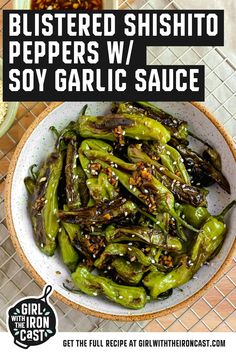 a white bowl filled with green peppers covered in sesame seeds and seasoning on top