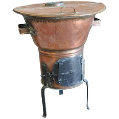 an old fashioned copper pot with a metal stand on it's legs and feet