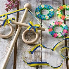 some crafting supplies are laying out on a wooden table with flowers and beads around them