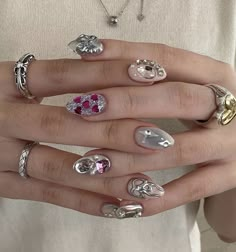 a woman's hand with many different types of rings on her fingers and hands