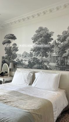 a large bed sitting in a bedroom next to a wall with a mural on it