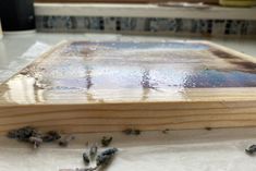 a piece of wood that has been stained with blue and white paint sitting on top of a table