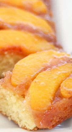 a close up of a piece of cake with peaches on it and some other pieces in the background