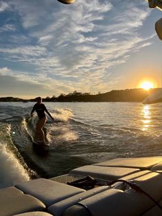 a person riding a surfboard on top of a body of water next to a boat