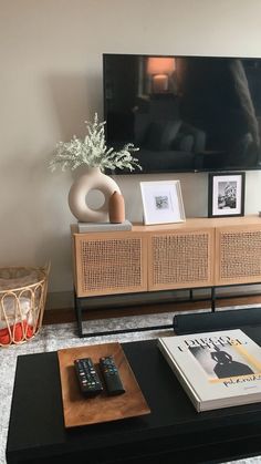 a flat screen tv sitting on top of a wooden entertainment center in a living room