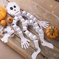 a wooden table topped with paper cut outs and pumpkins next to a jack - o'- lantern