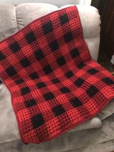 a red and black blanket sitting on top of a white chair