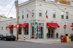 an italian restaurant with red awnings on the side of it's building