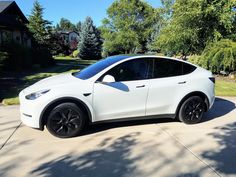 a white car parked in front of a house