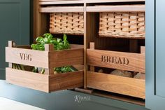 two wooden boxes filled with vegetables sitting on top of a counter