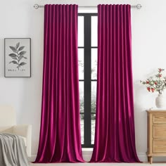 a living room with a large window covered in purple curtains