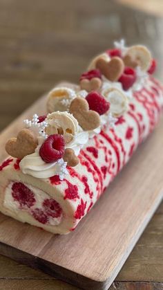 a piece of cake on a cutting board with raspberries and other toppings