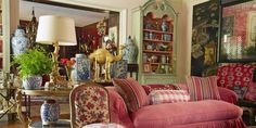 a living room filled with furniture and lots of vases on the wall next to it