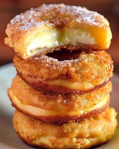 three donuts stacked on top of each other with powdered sugar in the middle