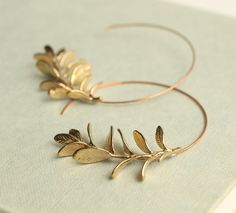 These rosemary leaf hoop earrings are made from solid brass with some amazing detail on the leaves.  They feature a detailed botanical sprig of leaves, in a rich golden brass tone.   The earwires are solid copper which provides an interesting contrast with the golden brass.   The hoop earrings measure 5cm (two inches) in diameter.   This piece of jewellery comes packaged in a nice recycled gift box with a handmade tag, all ready to give or keep. 🖤 FASTER SHIPPING 🖤 Need this fast? We offer a Faster Shipping option here: https://www.etsy.com/uk/listing/100107311/faster-shipping-priority-post-upgrade Please read the description before purchasing this listing, as we are unable to post every day! 🖤 GIFT MESSAGE & WRAP SERVICE! 🖤 For those of you who are sending gifts straight to your loved Gold Dangly Earrings, Woodland Earrings, Twig Branch, Handmade Hoop Earrings, Guest Hair, Branch Earrings, Silk Purse, Earrings Nature, Hoop Earrings Gold