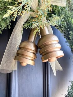 two golden bells hanging from the side of a door