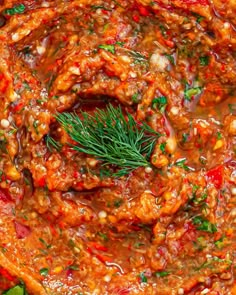 an overhead view of some food in a sauce with herbs and spices on the top