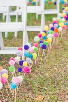 a bunch of colorful pom poms sitting in the grass