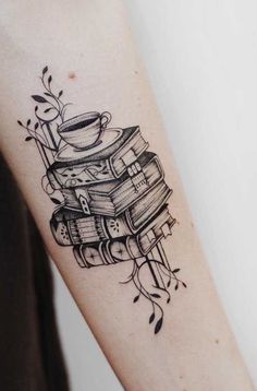 a small tattoo on the arm of a woman with coffee cups and books in it