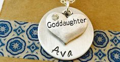 a necklace with the word goddaughter on it and a heart shaped pendant