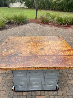 an old metal table sitting on top of a brick walkway