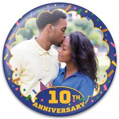 a man and woman kissing each other in front of a blue 10th anniversary photo plate