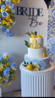 a three tiered wedding cake with lemons and blue flowers