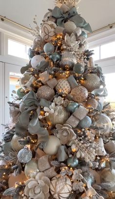 a christmas tree decorated with silver and white ornaments