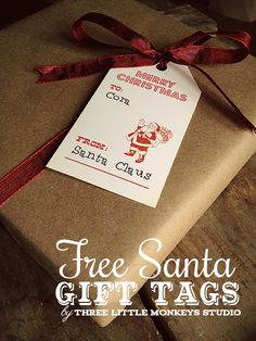 a present wrapped in brown paper with a red ribbon tied around it and the words free santa gift tags