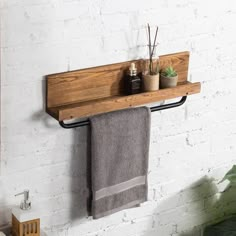 a towel rack with two towels hanging from it's sides next to a potted plant