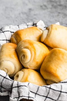 a basket filled with rolls sitting on top of a table