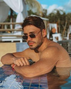 a man sitting in the water wearing sunglasses