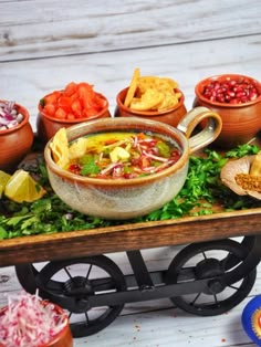 a table topped with bowls filled with different types of food next to chips and salsa