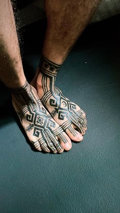 a close up of a person with tattoos on their hands and feet holding something in the air