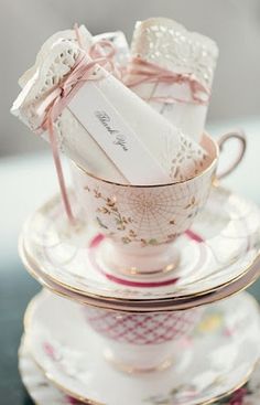 a stack of tea cups and saucers with napkins in them