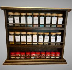 an old wooden shelf filled with lots of jars and spices on top of each other