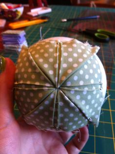 someone is holding an origami ball on a table