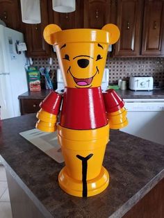 a winnie the pooh figure sitting on top of a kitchen counter