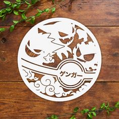 an image of a paper cut out of a pokemon ball on a wooden table with leaves