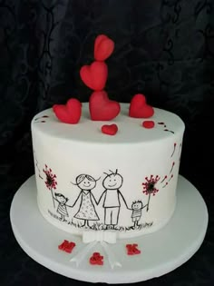 a white cake decorated with red hearts and two people holding hands on top of it