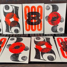 four red and black numbers are on white cards with orange circles in the middle,