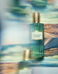 a bottle of gucci perfume sitting on top of a table next to the ocean