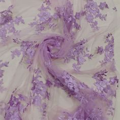 an image of purple flowers on a white background with sheer fabric in the foreground