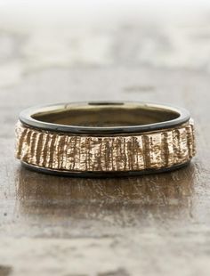 a close up of a wedding ring on a wooden table with no one around it