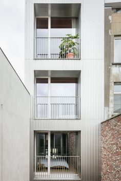 an apartment building with two balconies on the second floor