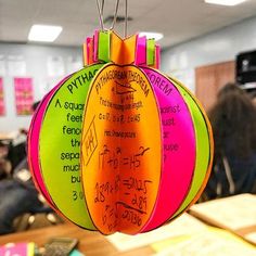 an ornament with writing on it hanging from a string in front of students