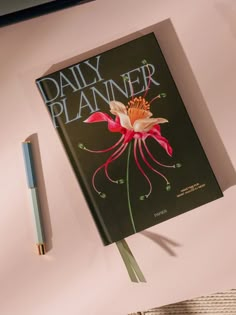 a book sitting on top of a pink table next to a pen and paper clip