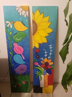 two painted boards with flowers and birds on them